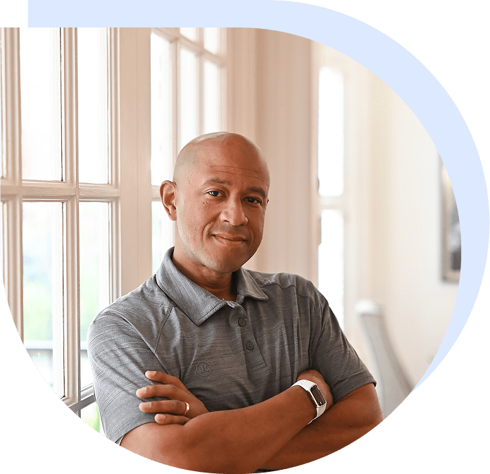 Man with arms crossed by window