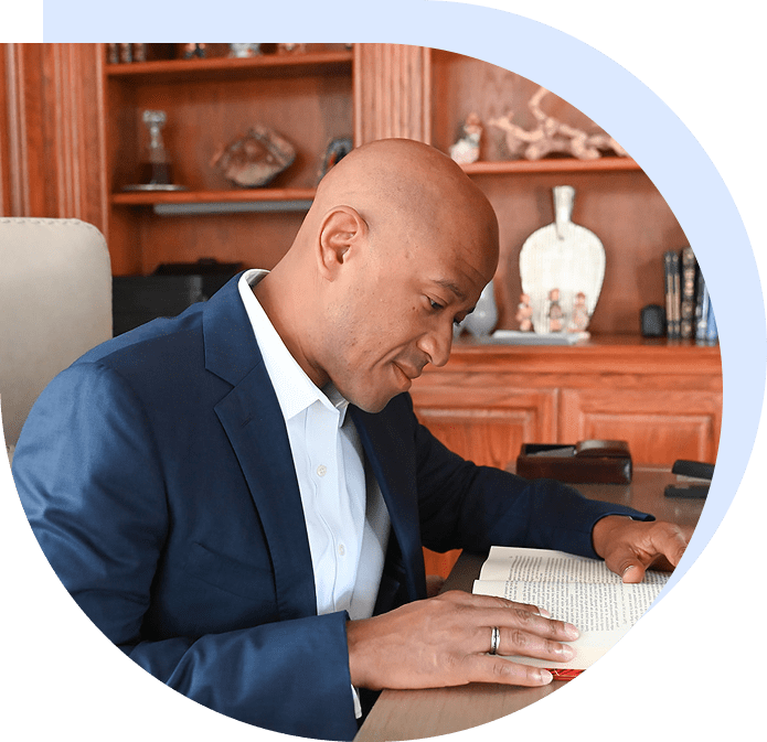 Man in suit reading book at desk