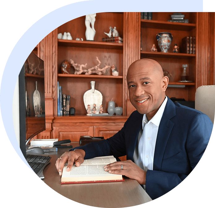 Smiling man in suit reading book at desk