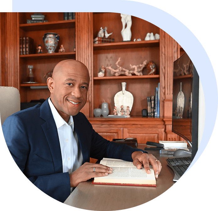 Smiling man reading book at wooden desk